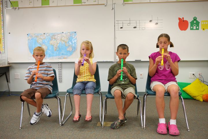 Elementary school students playing flutes