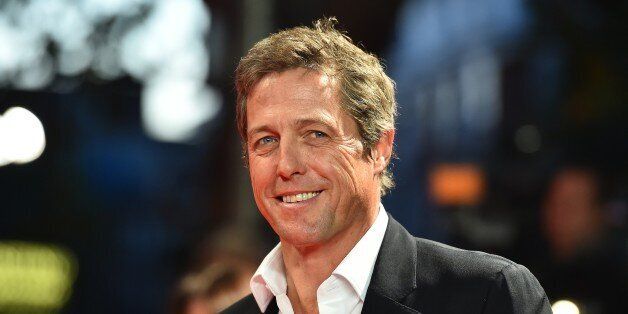 British actor Hugh Grant poses for pictures on the red carpet as he arrives to attend the European premier of his latest film 'The Rewrite' in London on October 7, 2014. AFP PHOTO/BEN STANSALL (Photo credit should read BEN STANSALL/AFP/Getty Images)