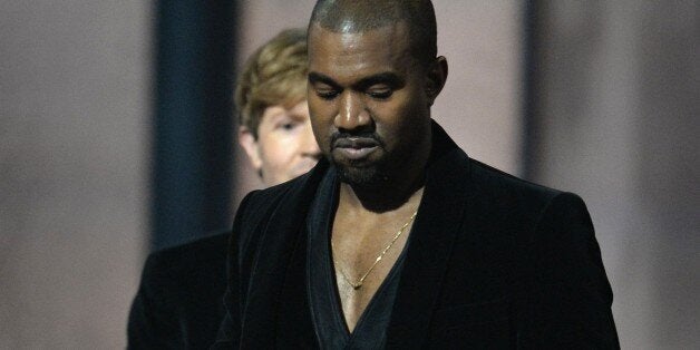 Winner for Album Of The Year Beck (background) reacts as Kanye West leaves the stage at the 57th Annual Grammy Awards in Los Angeles February 8, 2015. AFP PHOTO / ROBYN BECK (Photo credit should read ROBYN BECK/AFP/Getty Images)