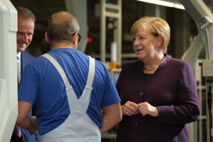 4 Noεμβρίου 2020. Η καγκελάριος Άγκελα Μέρκελ συνομιλεί με εργάτη στη γραμμή παραγωγής εργοστασίου της Volkswagen Group (Photo by Sean Gallup/Getty Images)