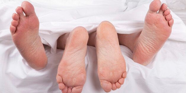 romantic senior feet in bed having sex under the sheets