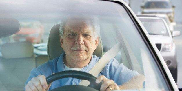 Elderly man driving car in traffic
