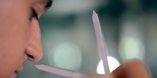 A student from Brazil, smells a fragrance melt on test strips in a laboratory at the Givaudan Perfumery School on July 4, 2012 in Argenteuil, northern suburb of Paris. The school opened in 1946. AFP PHOTO ERIC FEFERBERG (Photo credit should read ERIC FEFERBERG/AFP/Getty Images)