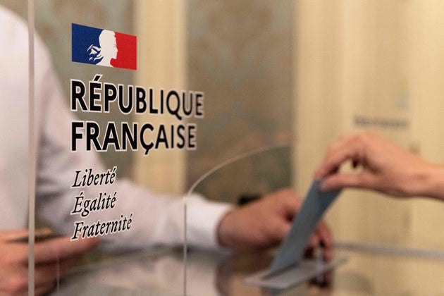 Un électeur dépose son bulletin dans un bureau de vote au Puy-en-Velay, pour le 1er tour des élections régionales, le 20 juin 2021. (Photo by THIERRY ZOCCOLAN/AFP via Getty Images)