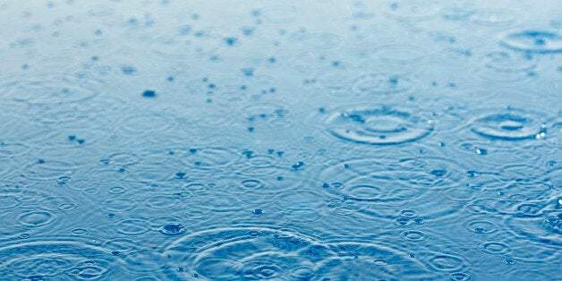 rain drops falling on the surface of water creating ripples