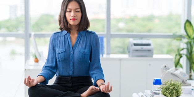 Asian businesswoman sitting on table and meditating