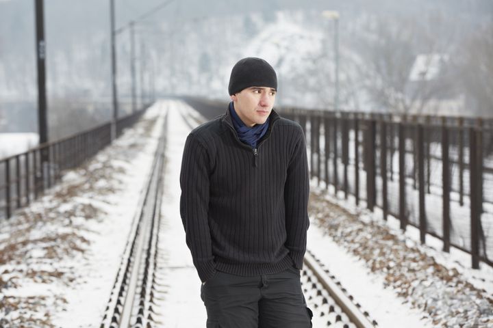 young man on railroad track in...