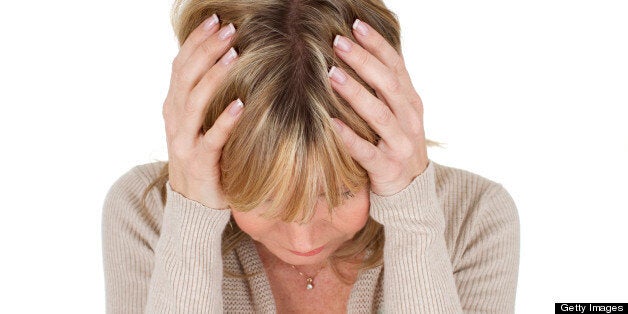 mature woman with her head in her hands as depression concept isolated on white background