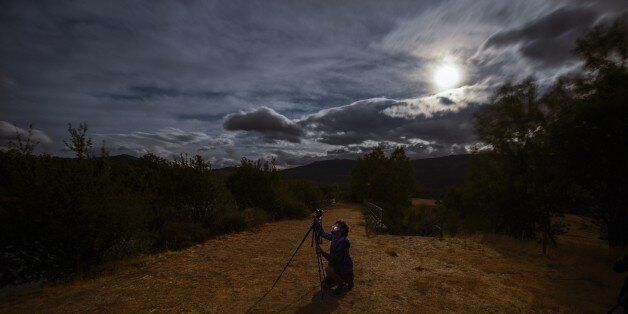 A photographer take pictures in the early hours of August 13, 2014 of a Perseids meteor shower in the night sky from the mountains of the Sierra Norte de Madrid near the municipality of Valle del Lozoya. The perseid meteor shower occurs every year in August when the Earth passes through the debris and dust of the Swift-Tuttle comet. AFP PHOTO / DANI POZO (Photo credit should read DANI POZO/AFP/Getty Images)