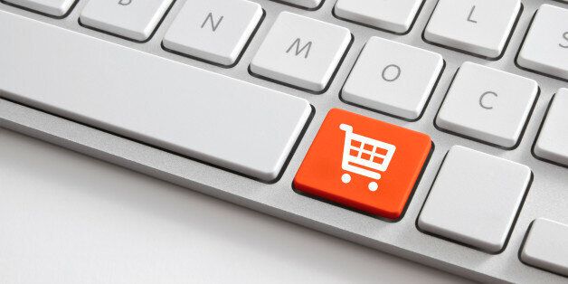 Online shopping concepts shooting of white computer keyboard with orange shopping cart button.