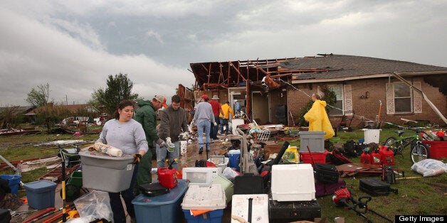 MOORE, OK - MAY 23: Volunteers help a co-worker to salvage belongings from her home after it was destroyed by a tornado May 23, 2013 in Moore, Oklahoma. The two-mile wide EF5 tornado touched down May 20 killing at least 24 people and leaving behind extensive damage to homes and businesses. U.S. President Barack Obama promised federal aid to supplement state and local recovery efforts. (Photo by Scott Olson/Getty Images)