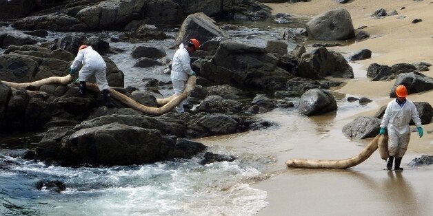 Port personnel clean a spillage of some three cubic metres of oil around in the coastal municipality of Quinteros, in Valparaiso, 170 km west of Santiago, on September 24, 2014. The spillage occured when a tanker's moorings broke off leaking the oil into the sea. AFP PHOTO / FRANCESCO DEGASPERI. (Photo credit should read FRANCESCO DEGASPERI/AFP/Getty Images)