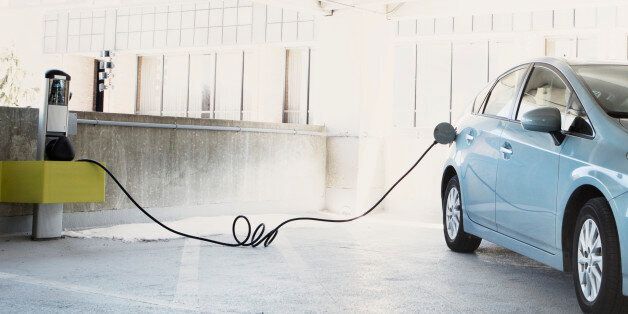 Hybrid car plugged in for electricity
