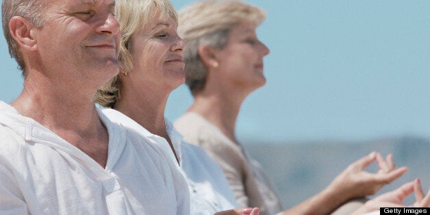 Three Seniors in a Row Sitting in the Lotus Position