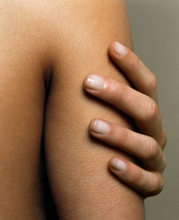 Woman touching arm, close-up