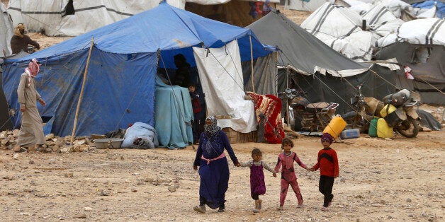 Syrian refugees stuck between the Jordanian and Syrian borders waiting to cross into Jordan, walk at a camp, after a group of them crossed into Jordanian territory, near the town of Ruwaished, at the Hadalat area, east of the capital Amman, May 4, 2016. REUTERS/Muhammad Hamed