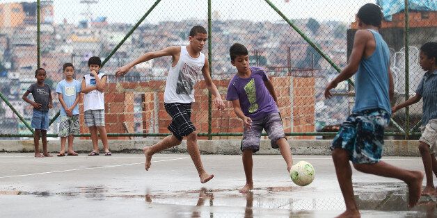RIO DE JANEIRO, BRAZIL - MAY 18: Boys play soccer in the Complexo do Alemao pacified community, or 'favela' on May 18, 2014 in Rio de Janeiro, Brazil. Ahead of the 2014 FIFA World Cup, Rio has seen an uptick in violence in its pacified slums, including Complexo do Alemao. A total of around 1.6 million Rio residents live in shantytowns, many of which are controlled by drug traffickers. (Photo by Mario Tama/Getty Images)