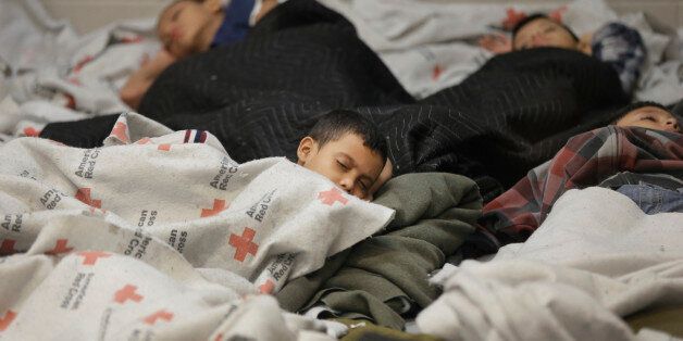 BROWNSVILLE, TX - JUNE 18: Detainees sleep in a holding cell at a U.S. Customs and Border Protection processing facility, on June 18, 2014, in Brownsville,Texas. Brownsville and Nogales, Ariz. have been central to processing the more than 47,000 unaccompanied children who have entered the country illegally since Oct. 1. (Photo by Eric Gay-Pool/Getty Images)