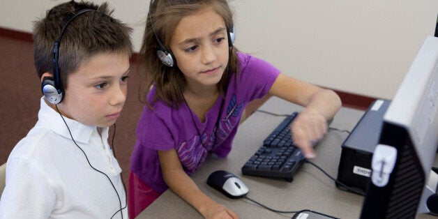 PHOENIX, AZ - OCTOBER 11: Ella Richardson helps Aidan Sawyer during class on October 11, 2013 at Horseshoe Trails Elementary School in Phoenix, AZ. Formal keyboarding instruction at the school began this year for second-graders, in anticipation of the Common Core curriculum. (Photo by David Jolkovski for The Washington Post via Getty Images)