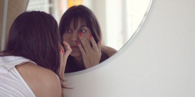 Woman looking in mirror.