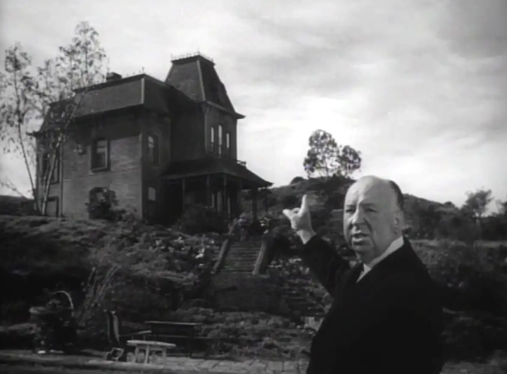 Alfred Hitchcock ante el motel de Psicosis, imagen perteneciente al tráiler oficial de la película.