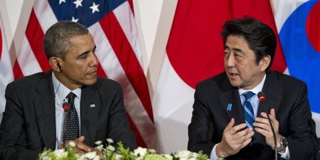 US President Barack Obama listens to Japanese Prime Minister Shinzo Abe (R) during a trilateral meeting with the South Korean president at the US ambassador's residence in The Hague on March 25, 2014 after they attended the Nuclear Security Summit (NSS). Obama hosted the much-anticipated first meeting between the Asian leaders with relations between Tokyo and Seoul at their lowest ebb in years, mired in emotive issues linked to Japan's 1910-45 colonial rule and a territorial dispute, as well as Japan's use of South Korean 'comfort women' sex slaves in wartime brothels. AFP PHOTO / Saul LOEB (Photo credit should read SAUL LOEB/AFP/Getty Images)