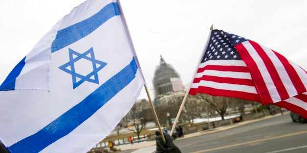 A pro-Israel demonstrators waves flags, toward the Capitol in Washington, Tuesday, March 3, 2015, as Israeli Prime Minister Benjamin Netanyahu addressed a joint meeting of Congress. In a speech that stirred political intrigue in two countries, Netanyahu told Congress that negotiations underway between Iran and the U.S. would "all but guarantee" that Tehran will get nuclear weapons, a step that the world must avoid at all costs. (AP Photo/Cliff Owen)