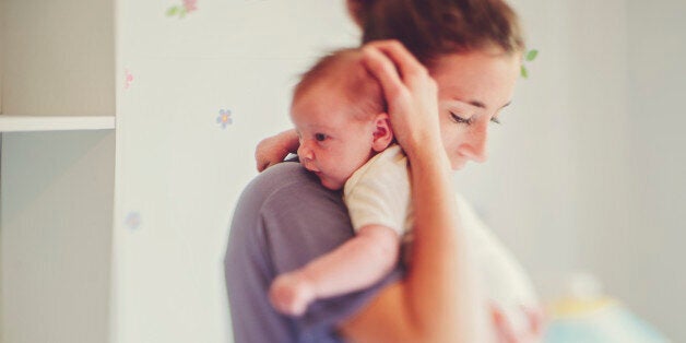 Mother holding her baby daughter in the nursery