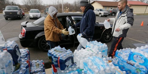 Volunteers load a vehicle with bottled water at Our Lady of Guadalupe Church, Friday, Feb. 5, 2016 in Flint, Mich. Michigan Gov. Rick Snyder is defending how his office responded to an email flagging a potential link between a surge in Legionnaires' disease and Flint's water. (AP Photo/Carlos Osorio)