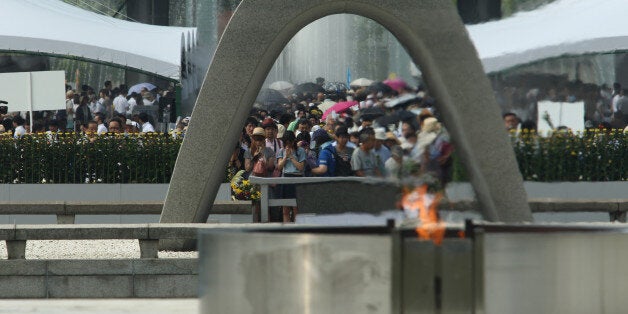 HIROSHIMA, JAPAN - AUGUST 06: Japanese people pray in front of a monument for atomic bomb vicitims at the Hiroshima Peace Memorial Park on the day of the 68th anniversary of the atomic bombing of Hiroshima on August 6, 2013 in Hiroshima, Japan. Japan marks the 68th anniversary of the first atomic bomb that was dropped on Hiroshima by the United States on August 6, 1945, killing an estimated 70,000 people instantly with many thousands more dying over the following years from the effects of radiation. Three days later another atomic bomb was dropped on Nagasaki, ending World War II. (Photo by Buddhika Weerasinghe/Getty Images)