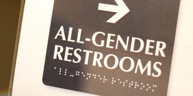 'All-Gender Restrooms' sign with some copy space at the top of the frame.
