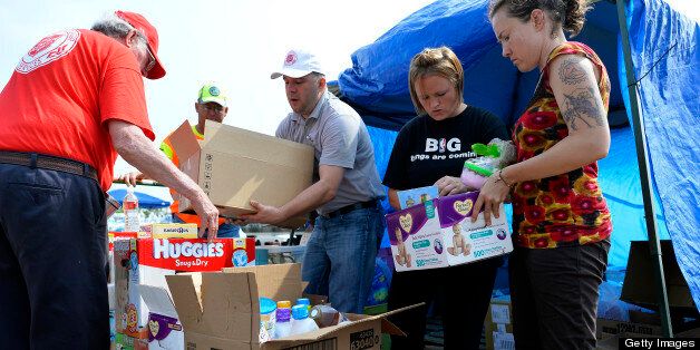 Volunteers arrange relief goods for tornado victims at a parking lot in Moore, Oklahoma, on May 24, 2013. The tornado, one of the most powerful in recent years, killed 24 people, injured 377, damaged or destroyed 1,200 homes and affected an estimated 33,000 people in this Oklahoma City suburb, officials said in their latest update. Initial damages have been estimated at around $2 billion. AFP PHOTO/Jewel Samad (Photo credit should read JEWEL SAMAD/AFP/Getty Images)