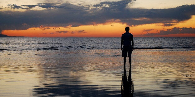 a man watching the sunset over...