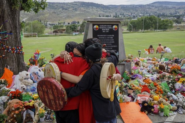 Des personnes s'embrassent devant un mémorial après la découverte des restes de 215 enfants près d'un ancien pensionnat de Marieval, le 4 juin 2021