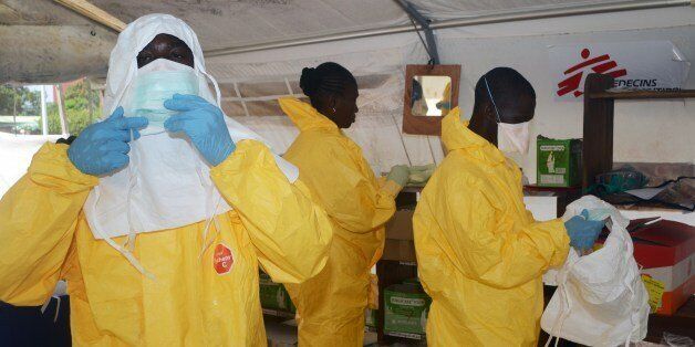 A picture taken on June 28, 2014 shows members of Doctors Without Borders (MSF) putting on protective gear at the isolation ward of the Donka Hospital in Conakry, where people infected with the Ebola virus are being treated. The World Health Organization has warned that Ebola could spread beyond hard-hit Guinea, Liberia and Sierra Leone to neighbouring nations, but insisted that travel bans were not the answer. To date, there have been 635 cases of haemorrhagic fever in Guinea, Liberia and Sierra Leone, most confirmed as Ebola. A total of 399 people have died, 280 of them in Guinea. AFP PHOTO / CELLOU BINANI (Photo credit should read CELLOU BINANI/AFP/Getty Images)