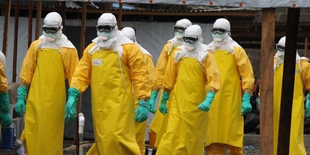 Health care workers, wearing a protective suits, leave a high-risk area at the French NGO Medecins Sans Frontieres (Doctors w