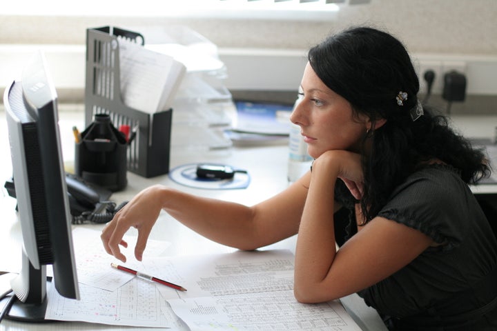 Girl works in office with computer and paper works