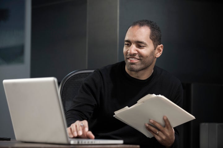 Mixed race man using laptop