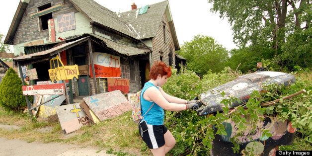 DETROIT, MI - JUNE 16: A volunteer helps clean up abandoned homes as part of the Foster the People, Foster the Future: Do Good Project at Heidelberg Project on June 16, 2012 in Detroit, Michigan. (Photo by Paul Warner/Getty Images)