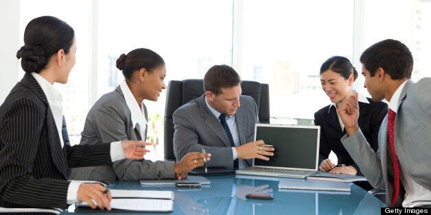 Group of Five multi-ethnic business people at a meeting in board room.