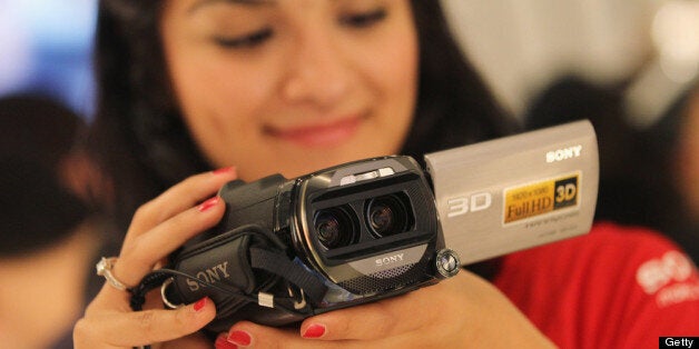 BERLIN, GERMANY - SEPTEMBER 02: A stand hostess demonstrates a 3D camcorder at the Sony stand at the IFA 2011 consumer electonics and appliances trade fair on the first day of the fair's official opening on September 2, 2011 in Berlin, Germany. The IFA 2011 will be open to the public from September 2-7. (Photo by Sean Gallup/Getty Images)