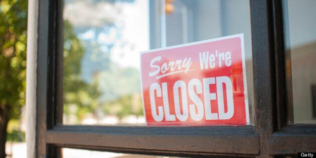 'Sorry, We're Closed Sign in a small town main street storefront window.Shot in Mason, Michigan.'