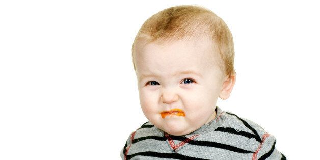 cute baby eating pureed carrots