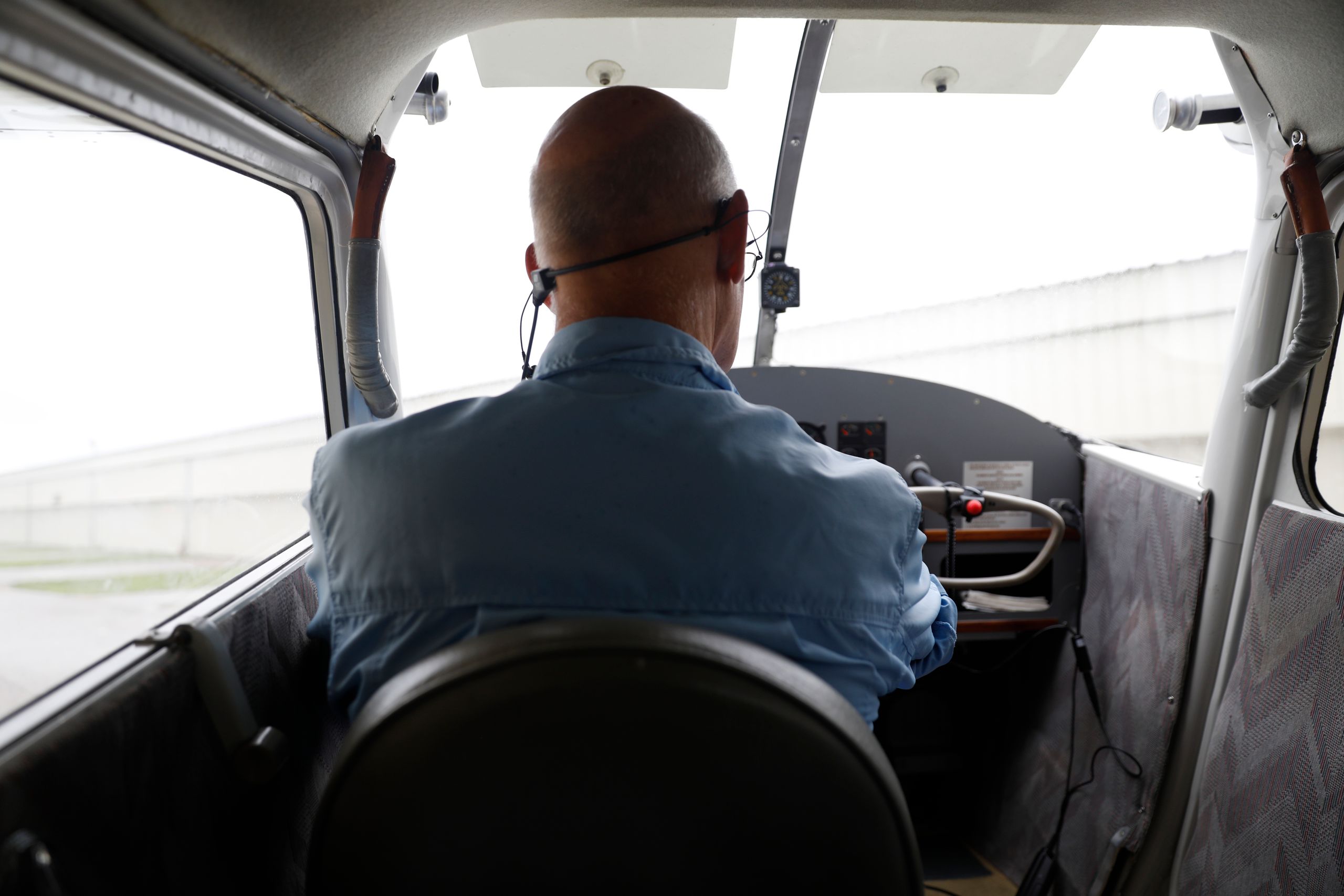 Carl Eisen, a former airline pilot, does a preflight and maintenance check on his antique airplane before flying out of the P