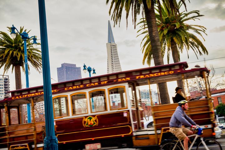 A motion blurred Cable Car on The Embarcadero near Washington street the Transamerica Pyramid background San Francisco California USA