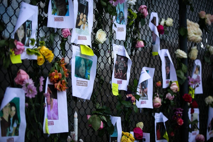 Photos of missing residents are posted at a makeshift memorial at the site of the collapsed building in Surfside.