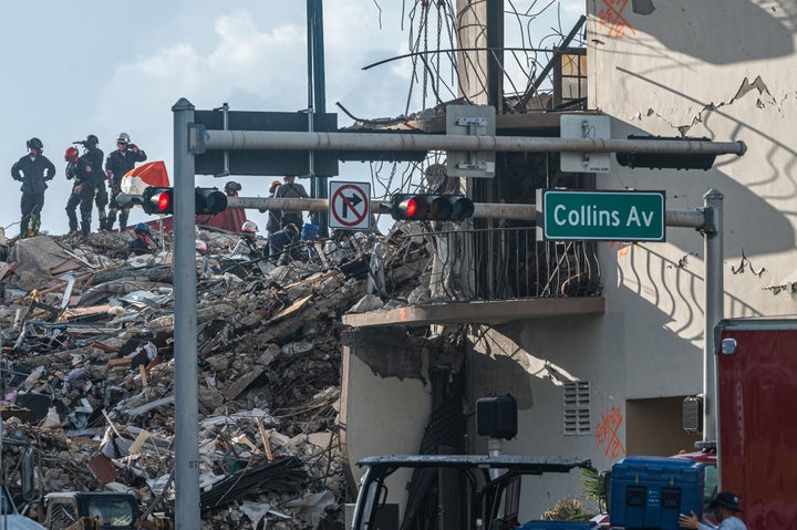 Members of the South Florida Urban Search and Rescue team look for possible survivors in the partially collapsed 12-story Champlain Towers South condo building on Sunday in Surfside, Florida.