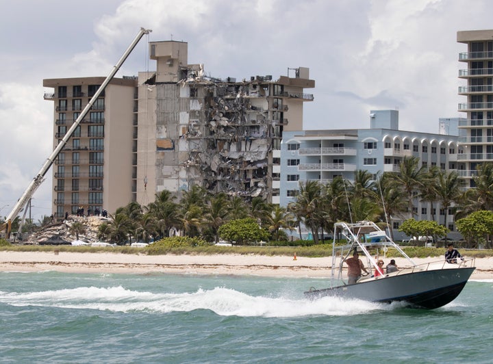 A boat passes offshore as members of the South Florida Urban Search and Rescue team look for possible survivors in the partially collapsed building.