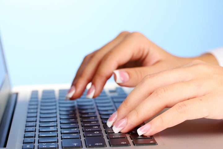 hands typing on laptop keyboard ...