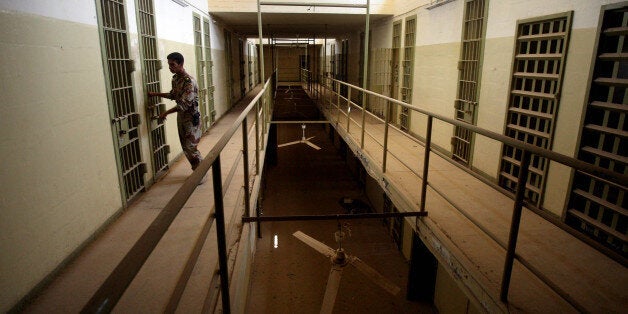 FILE - In this Sept. 2, 2006, file photo, an Iraqi army soldier closes the door of a cell, in Abu Ghraib prison after the Iraqi government took over control from U.S. forces, on the outskirts of Baghdad, Iraq. A defense contractor whose subsidiary was accused in a lawsuit of conspiring to engage in torture at the infamous Abu Ghraib prison in Iraq has paid $5.28 million to 71 former inmates held there and at other U.S.-run detention facilities between 2003 and 2007. The settlement in the case involving Engility Holdings Inc. of Chantilly, Va., marks the first successful effort by lawyers for former prisoners at Abu Ghraib and other detention centers to collect money from a U.S. defense contractor in lawsuits alleging torture. Another contractor, CACI, is expected to go to trial over similar allegations this summer. (AP Photo/Khalid Mohammed, File)